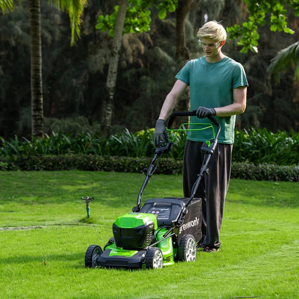 מכסחת דשא 46 ס״מ 48 וולט נטענת נסיעה עצמית, Greenworks GD24X2LM46SP: כיסוח מדשאה רחבה מול גדר חיה, מבט מלפנים ממרחק