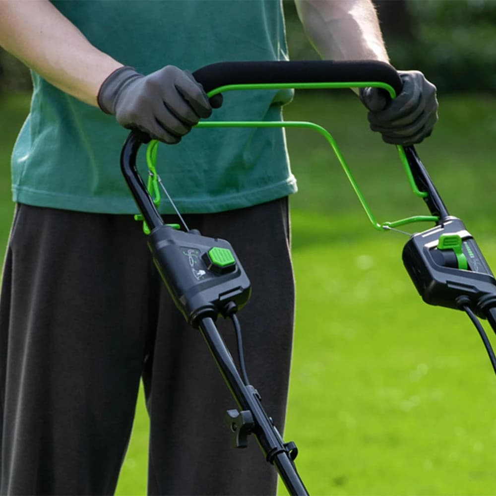 מכסחת דשא 46 ס״מ 48 וולט נטענת נסיעה עצמית, Greenworks GD24X2LM46SP: תקריב של ידית האחיזה עם ידית הנסיעה העצמית, בידיים עם כפפות