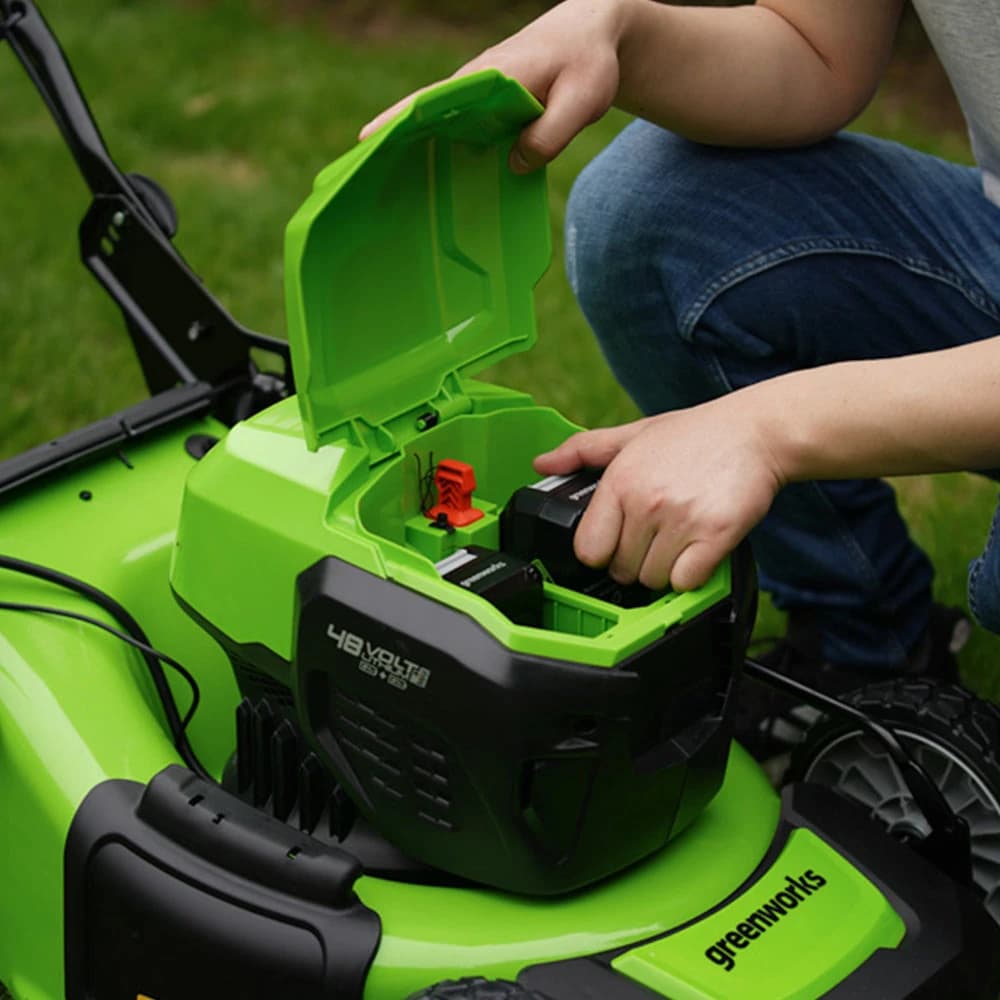 מכסחת דשא 46 ס״מ 48 וולט נטענת נסיעה עצמית, Greenworks GD24X2LM46SP: תקריב של תא הסוללות פתוח, יד מכניסה סוללה ולצידה מפתח הבטיחות האדום