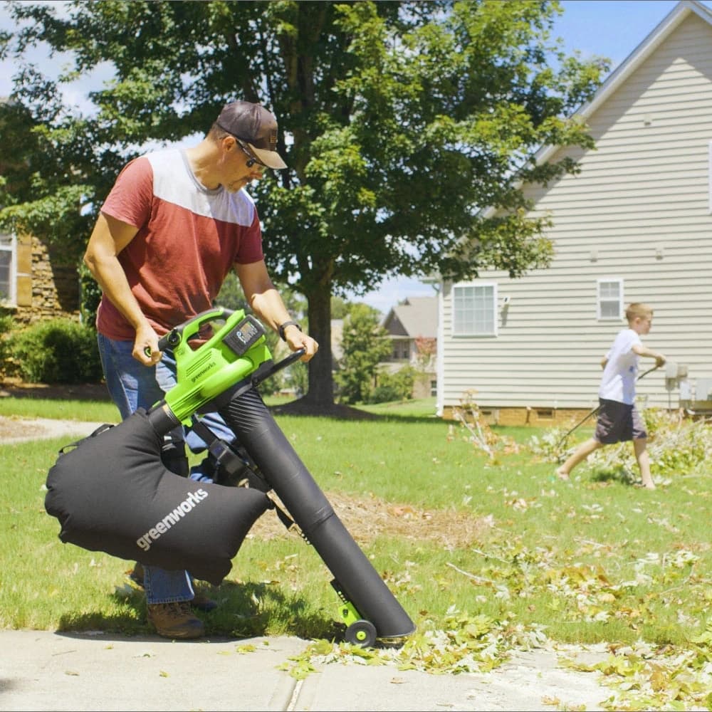 מפוח עלים 48 וולט נטען דור 2, Greenworks 2409207: שאיבת עלים מהדשא אל שק האיסוף, הכלי במצב שואב עם הגלגלים על הקרקע