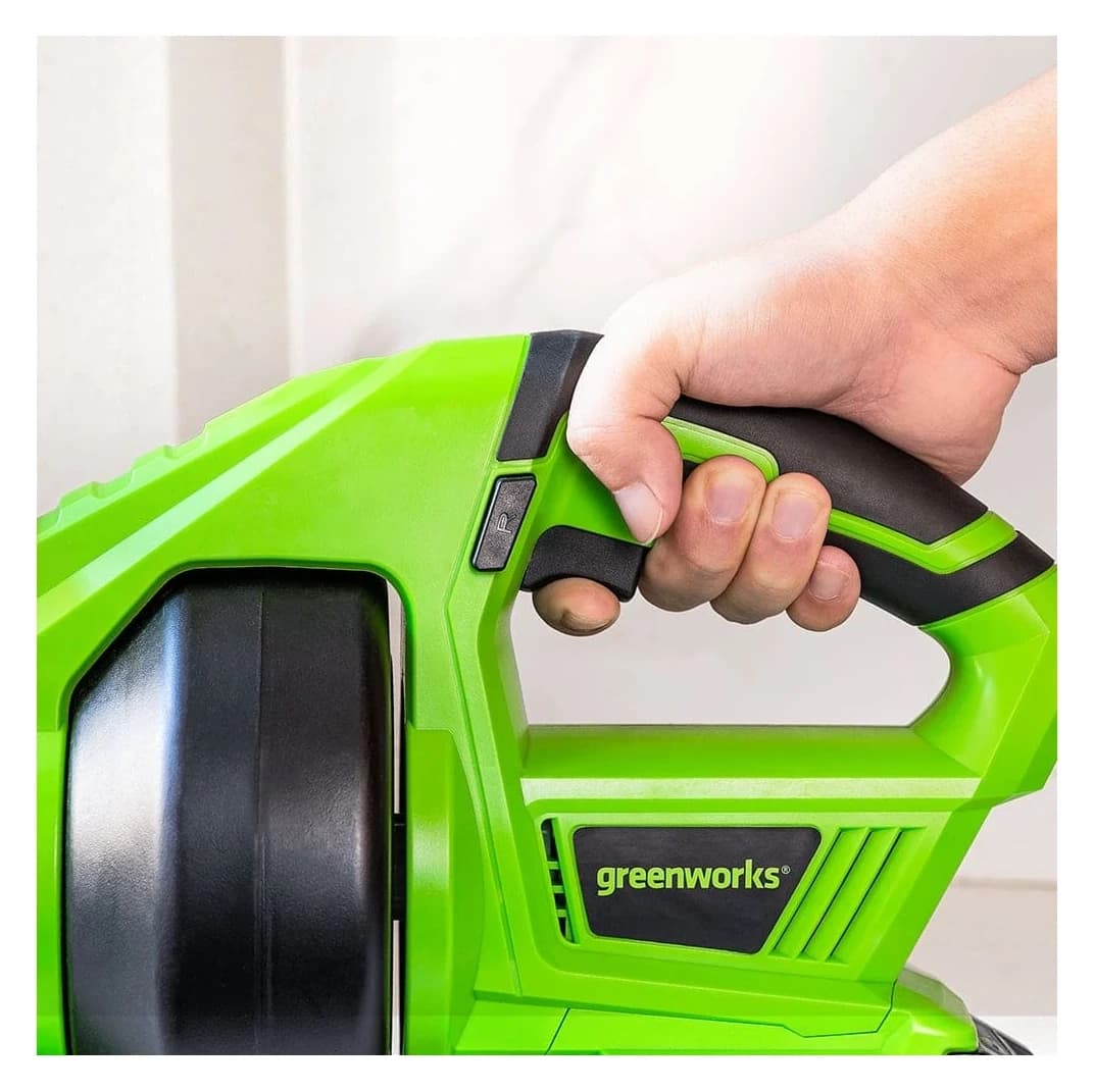 פתיחת סתימות 24 וולט נטענת גוף בלבד, Greenworks G24DA: תקריב של יד שאוחזת בידית האחורית, ליד תוף הספירלה והמתג