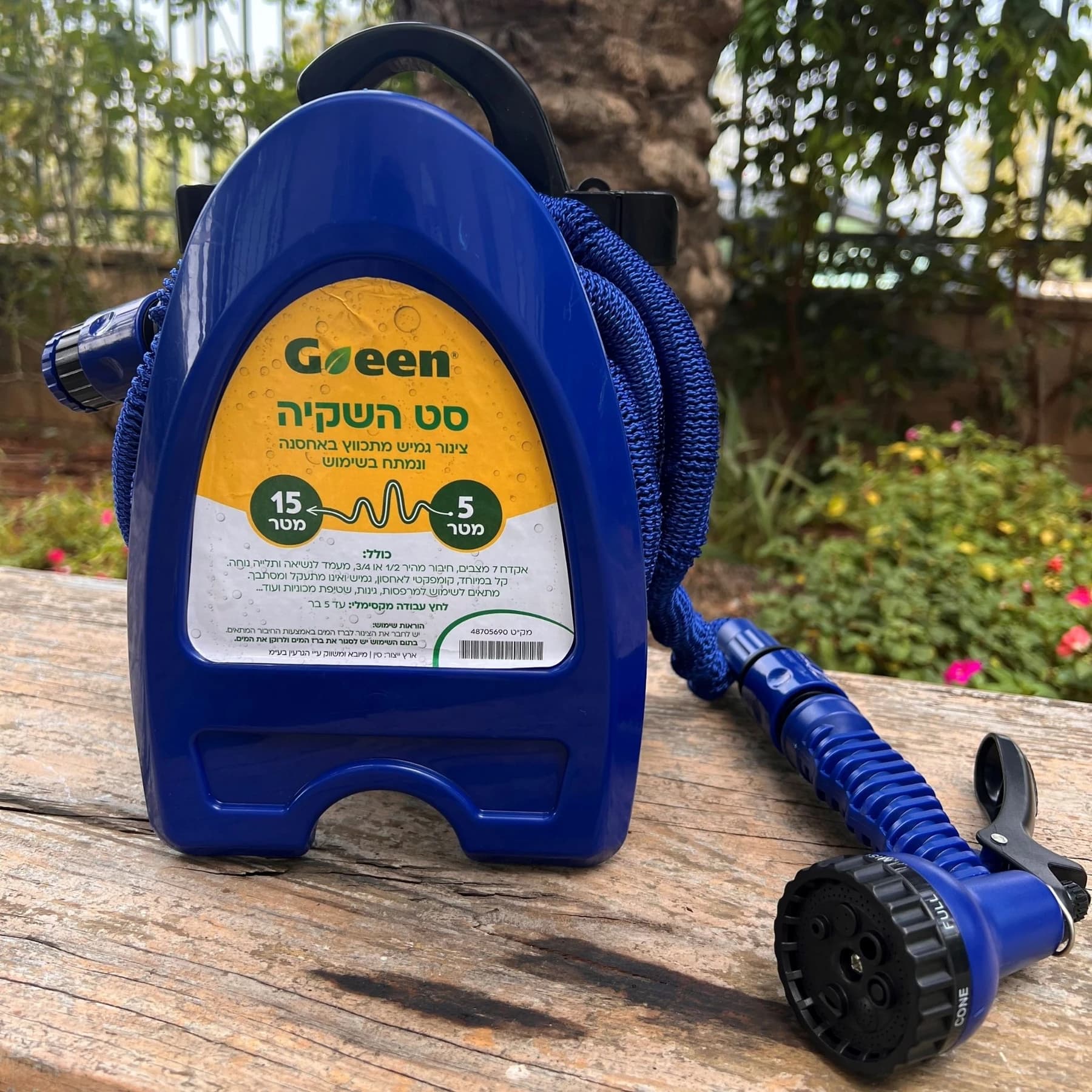 צינור מתארך כחול GREEN על מעמד עם אקדח, על גדם עץ בגינה